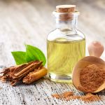 Cinnamon bark with essential oil on wooden background